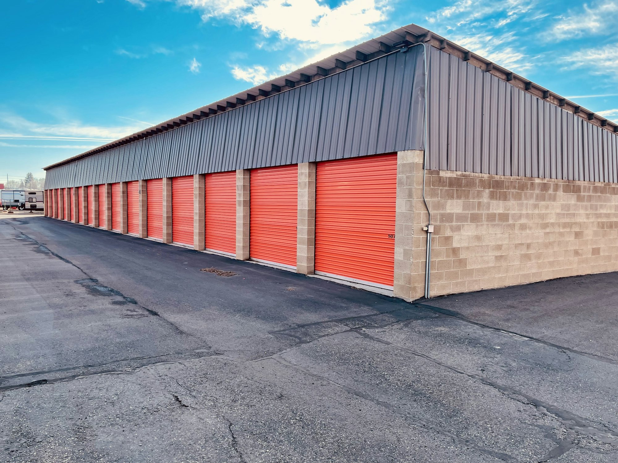 A row of storage units with red roll-up doors